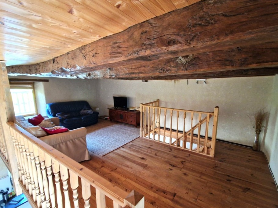 Mezzanine au 1er étage avec coin détente et TV.