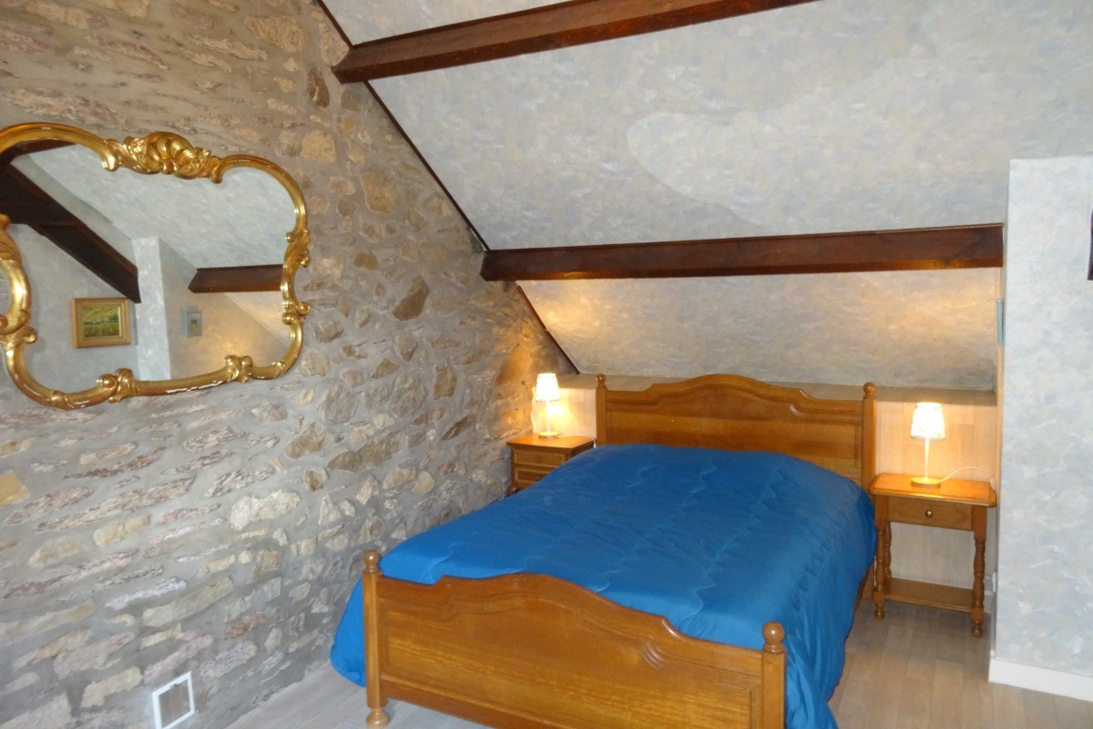 Chambre à l'étage pour 2 personnes (lit 140). Mur en pierres apparentes et coin détente. Possibilité d'un couchage supplémentaire (lit tiroir)
