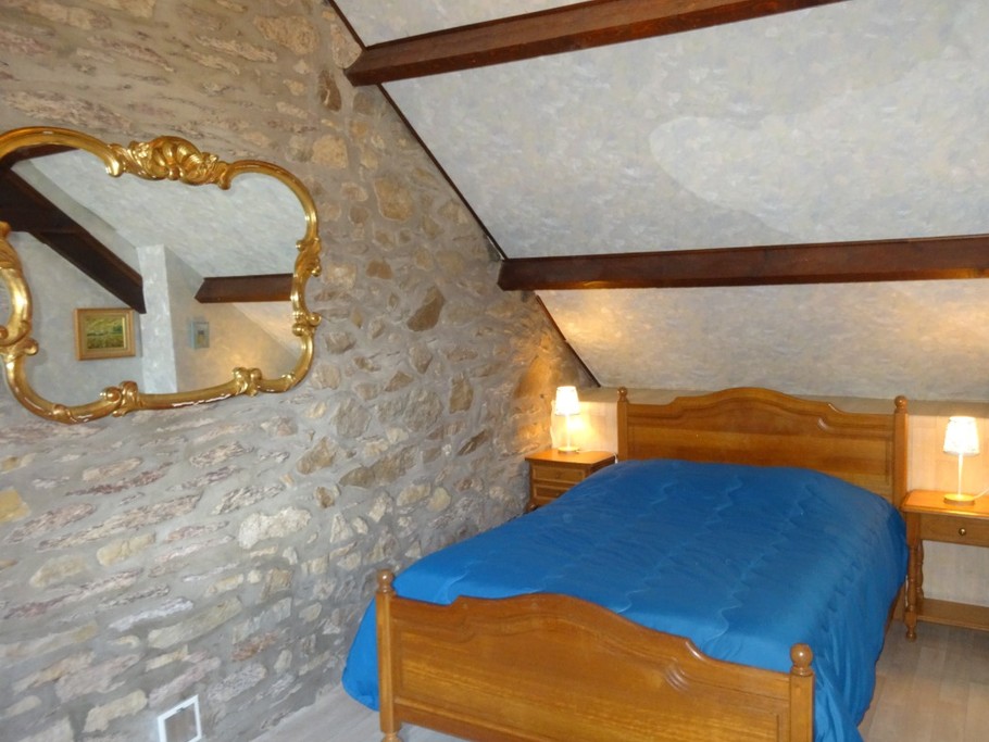 Chambre à l'étage pour 2 personnes (lit 140). Mur en pierres apparentes et coin détente. Possibilité d'un couchage supplémentaire (lit tiroir)