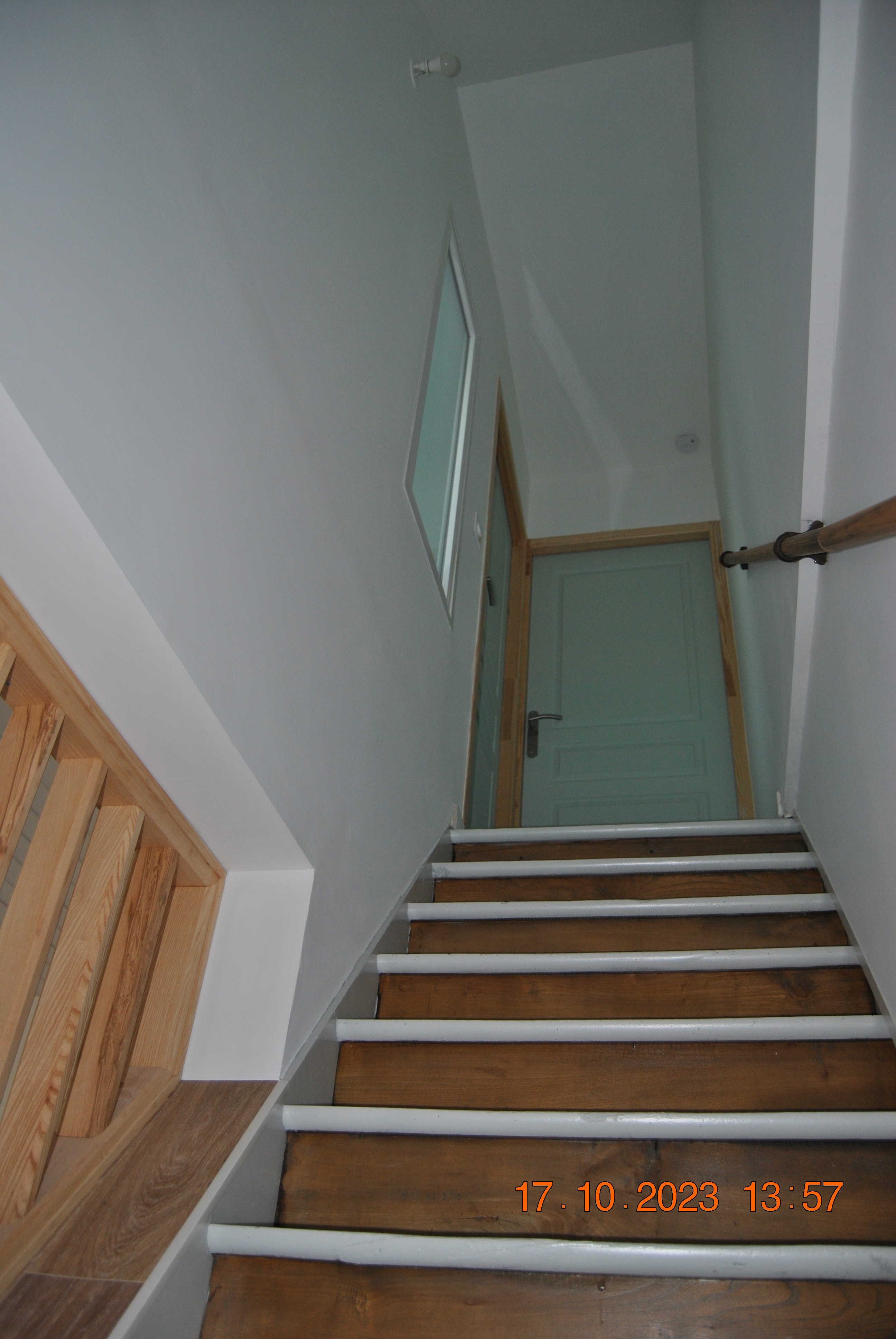 couloir d'accès aux chambres avec son escalier et un détecteur de fumée sur le plafond du palier.