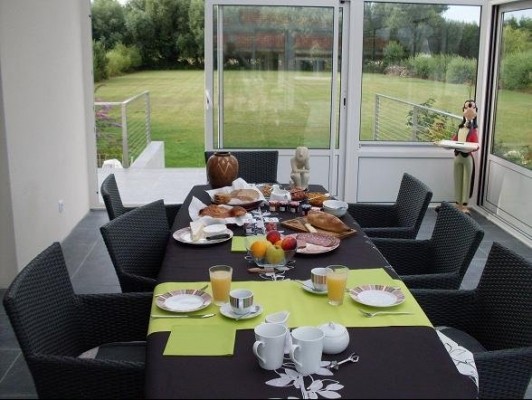 Petit déjeuner dans la veranda avec vue sur le jardin et les 'Pic-Verts'
