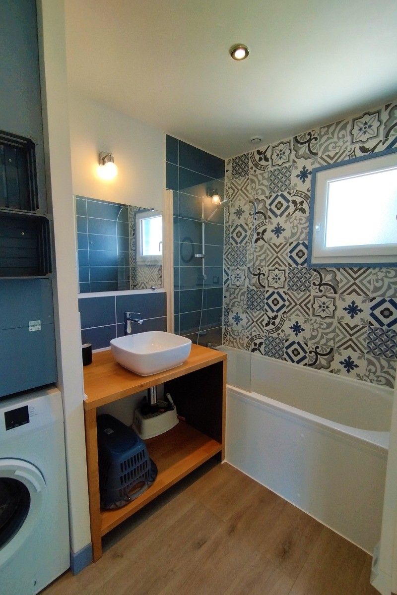 Salle de bain avec baignoire et machine à laver