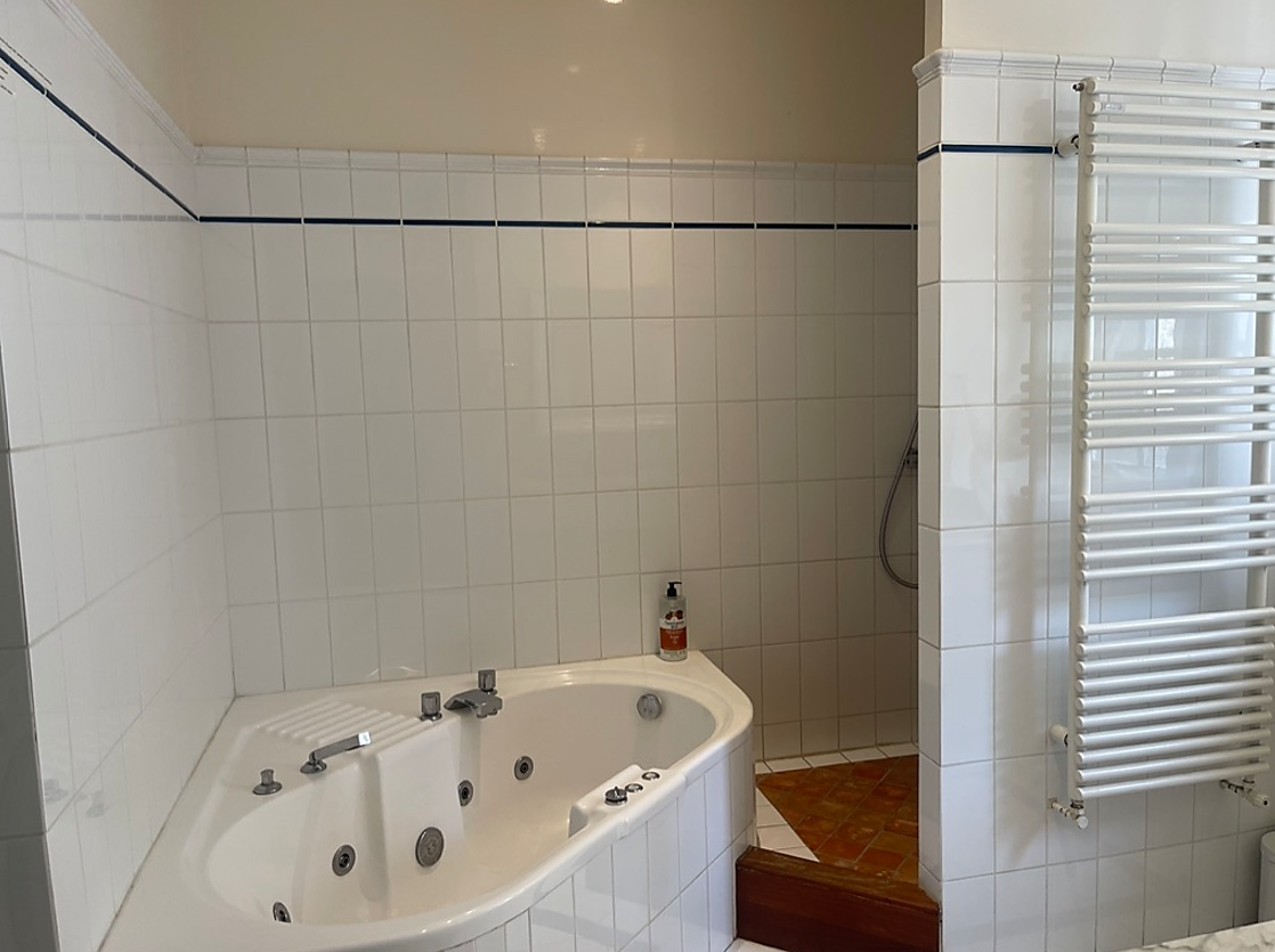 Bathroom with whirlpool bath, large shower and double washbasin unit.  Separate WC.