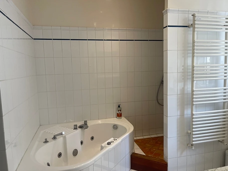 Bathroom with whirlpool bath, large shower and double washbasin unit. Separate WC.