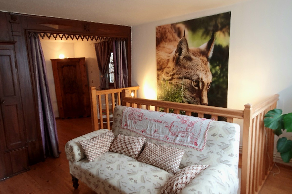 Coin canapé de l'étage, chambre derrière les rideaux