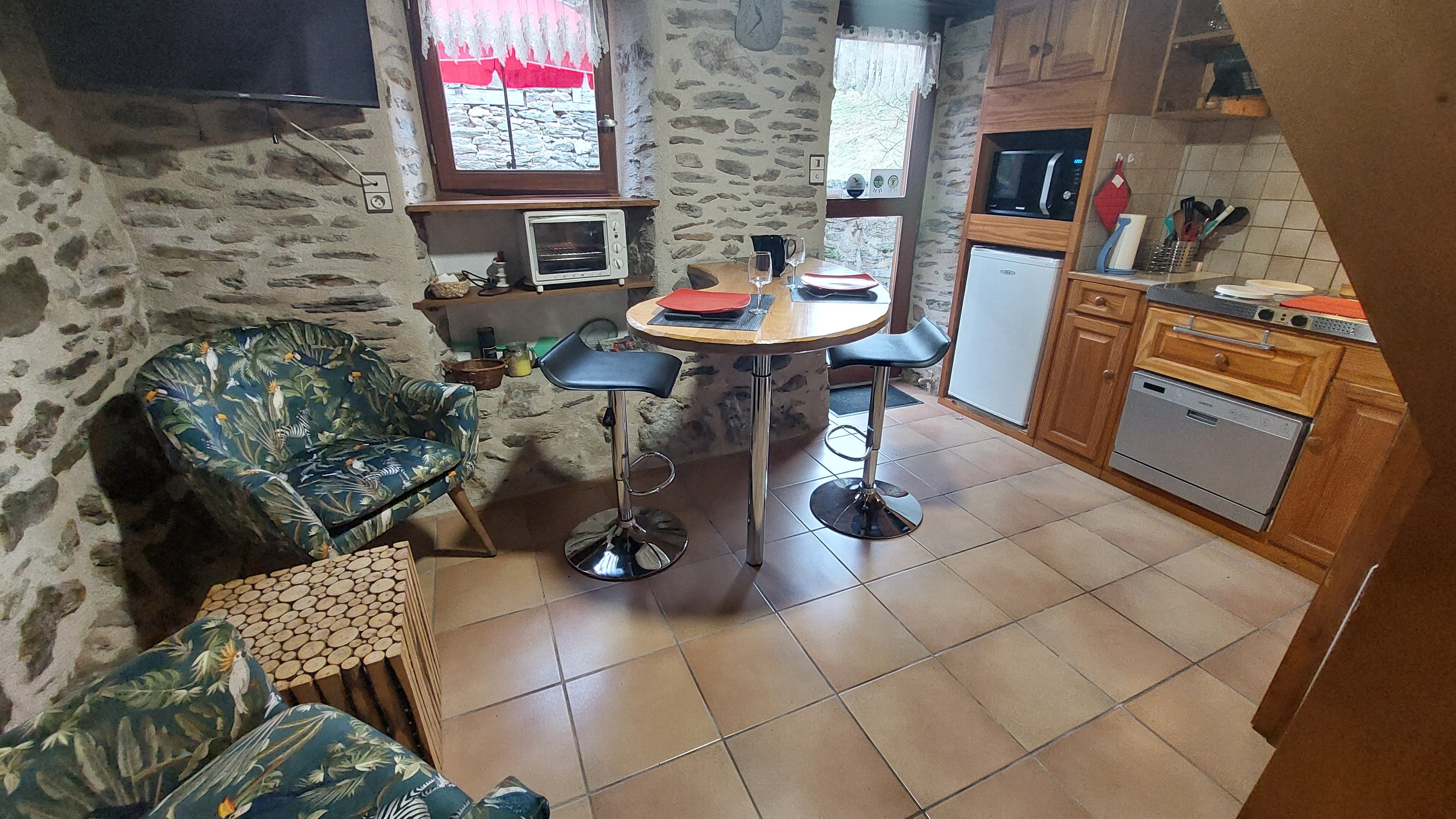 Pièce de vie du micro-gîte avec coin cuisine équipé, ambiance chaleureuse et fonctionnelle