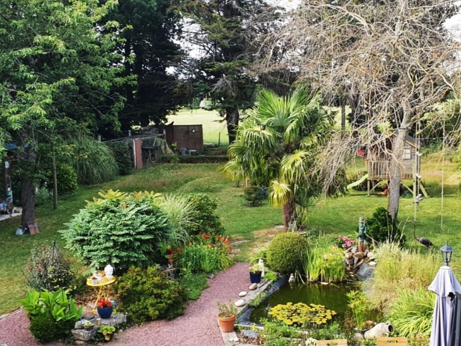 Grand jardin fleuri et ombragé.