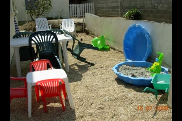 jardin clos avec salon de jardin, chaises longues et barbecue