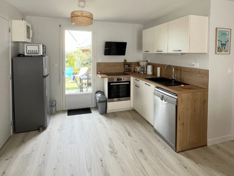 Au rez-de-chaussée, coin cuisine toute aménagée dans la grande pièce de vie contenant aussi un coin salon à l'entrée et coin séjour. Accès direct à la terrasse depuis la cuisine .