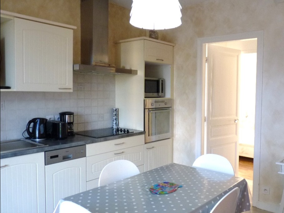 Coin séjour avec cuisine toute équipée dans la pièce de vie, avec accès direct à la terrasse privative. Au fond, la chambre et la salle d'eau.