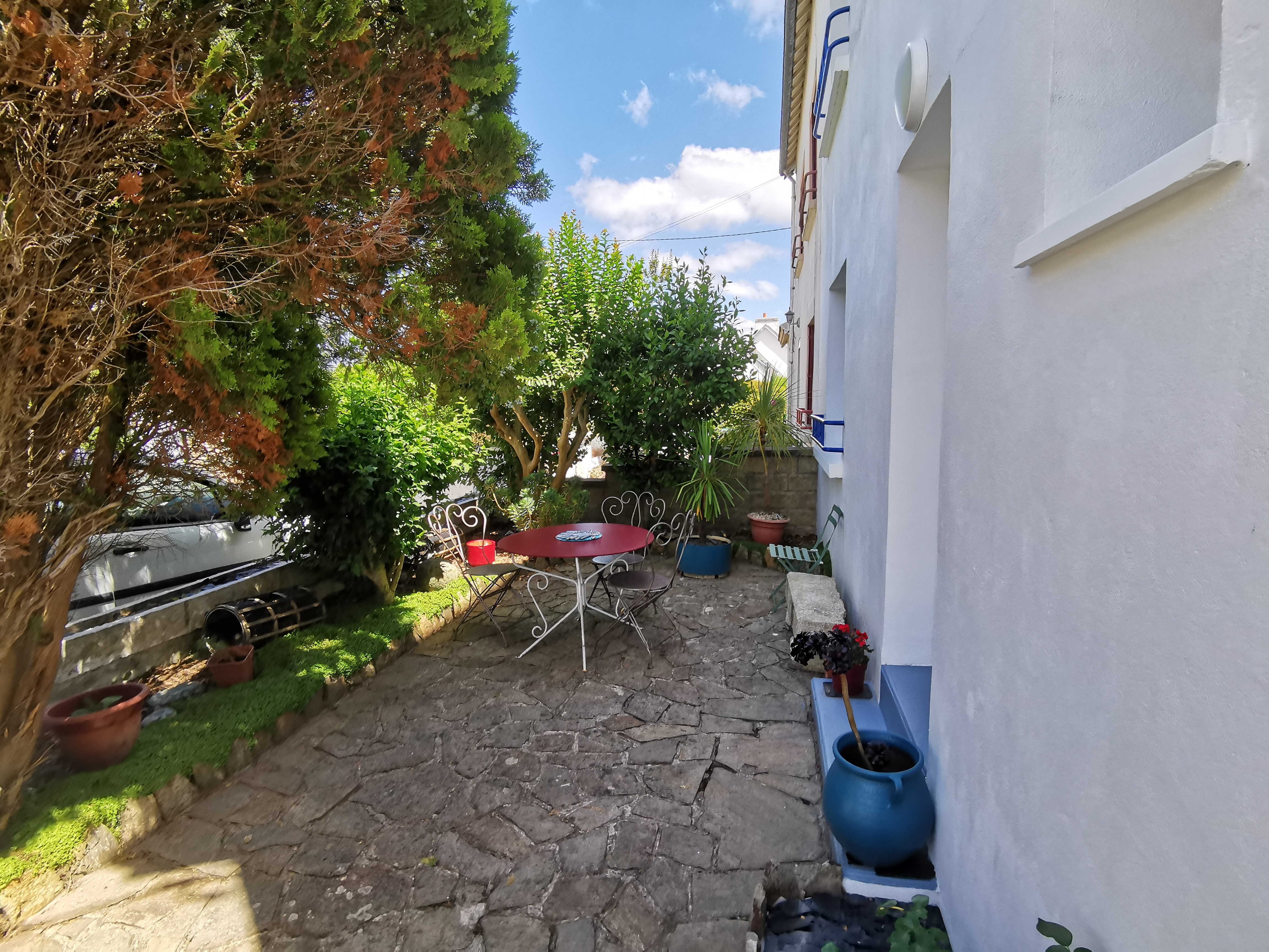 Petite cour devant la maison à l'ombre des arbres