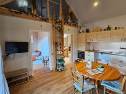 Open-plan living area with a fitted kitchen, lounge and dining table.