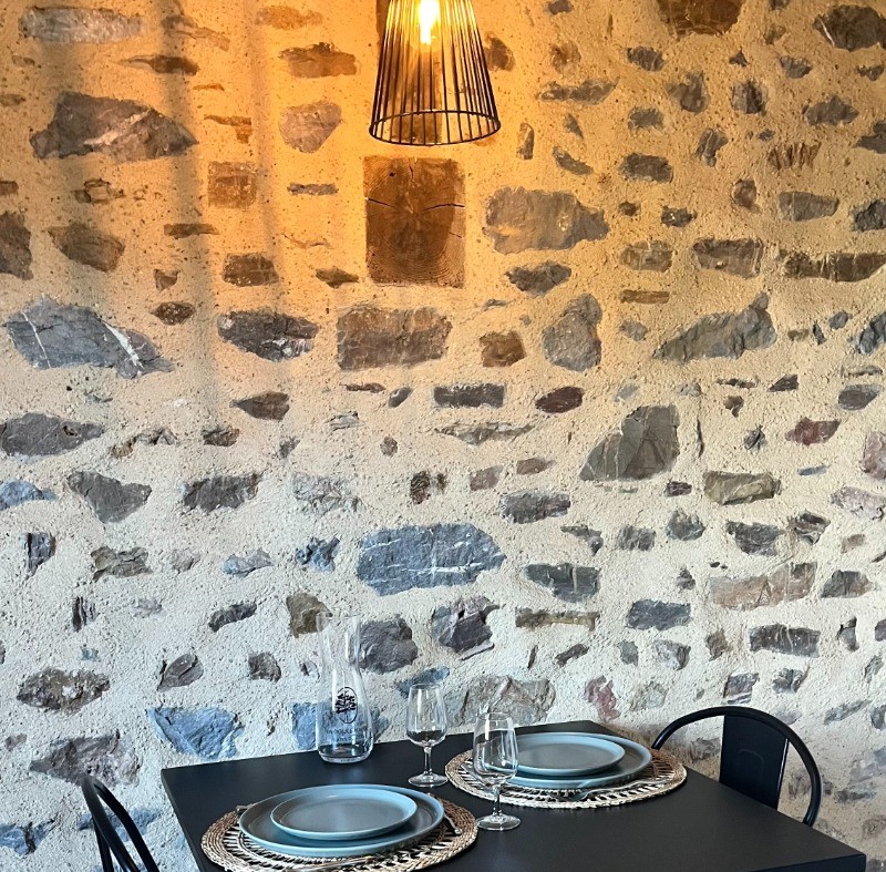 Cuisine indépendante avec coin repas (mur en pierres apparentes de pays)