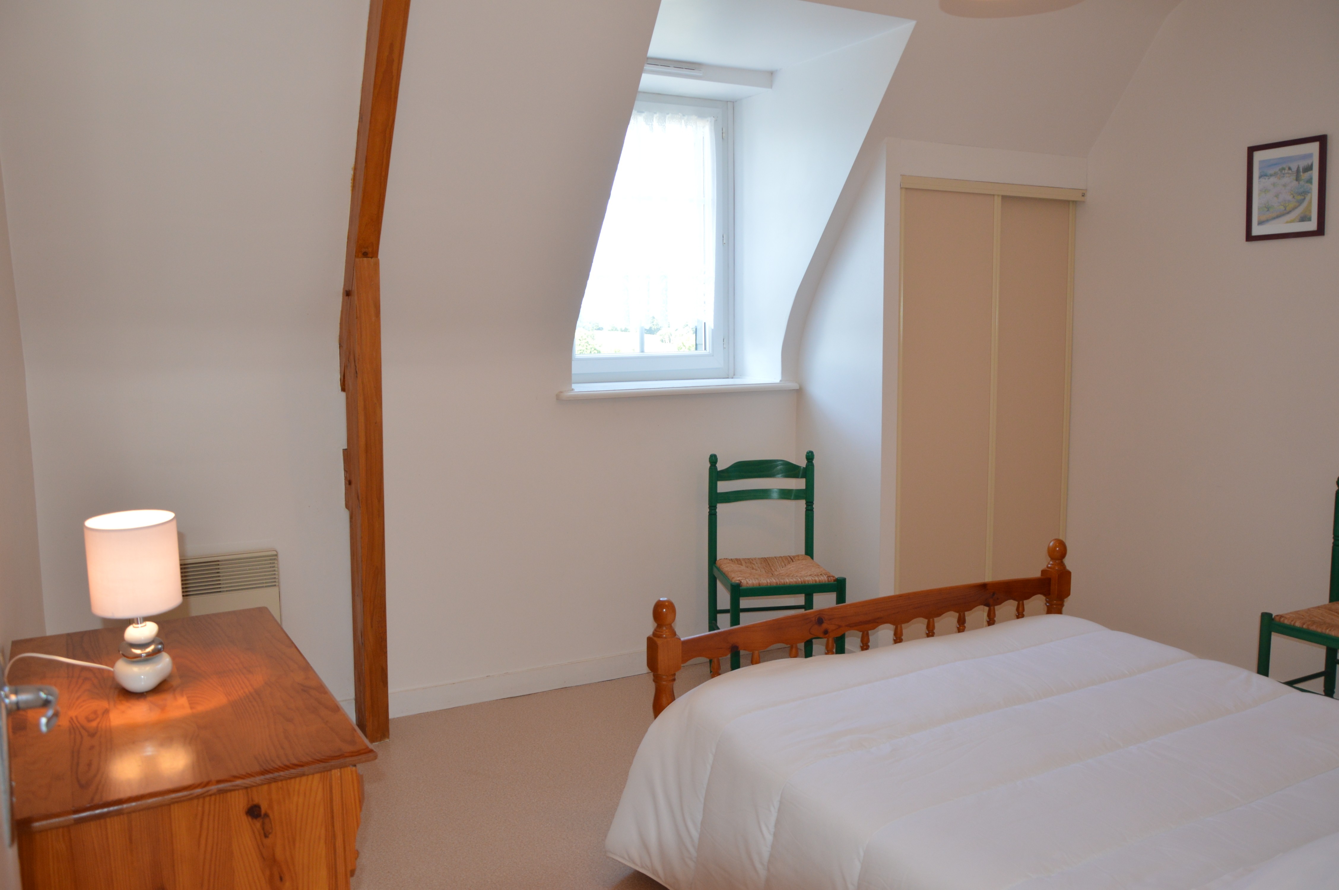 Chambre indépendante pour 2 personnes avec lit 140x190 cm, commode, armoire et chaises.