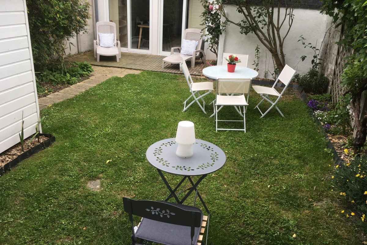jardin  clos avec 2 tables , 6 chaises  arbres fruitiers et fleurs