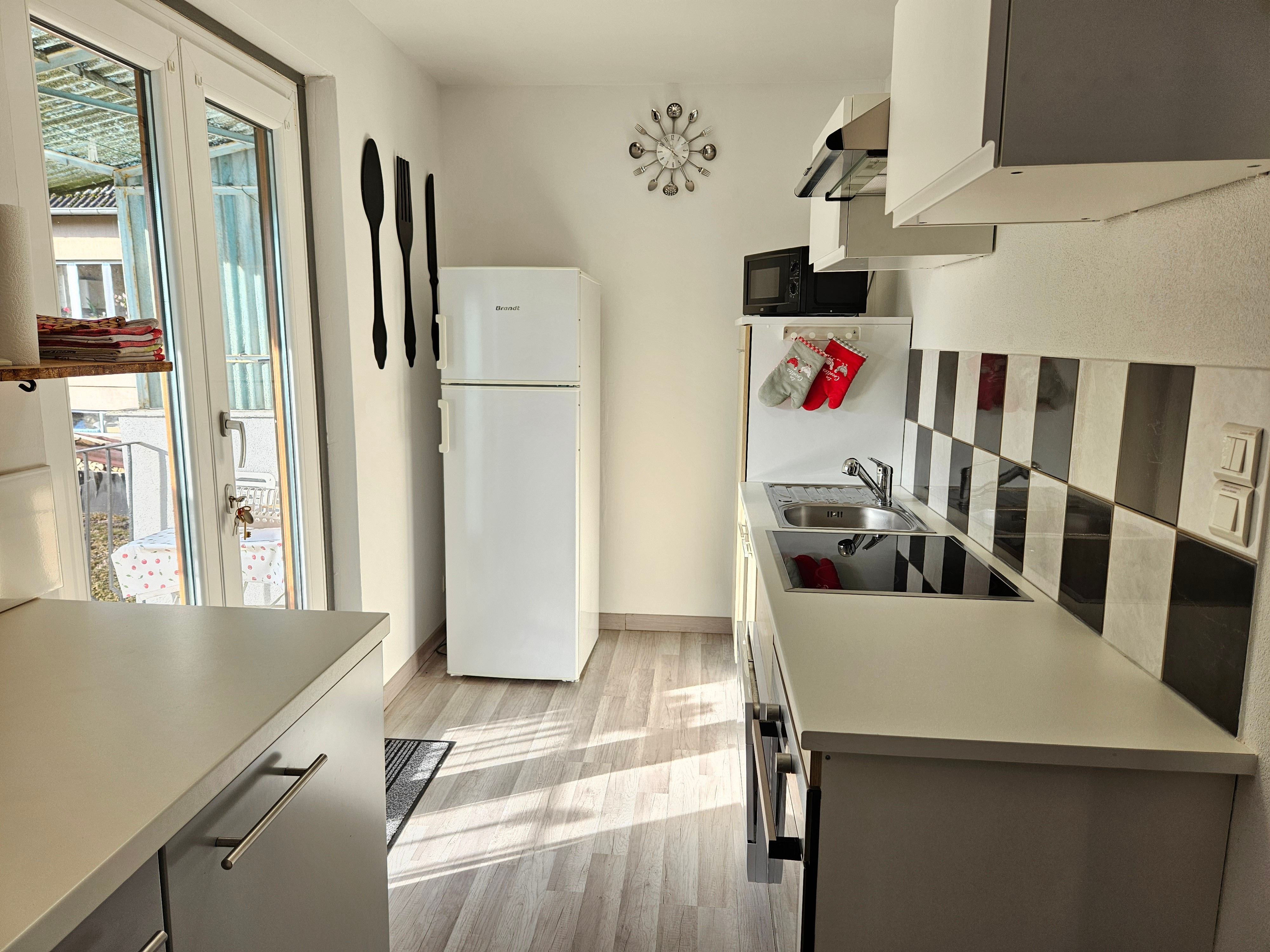 Fully-equipped kitchen with induction hob, oven, dishwasher, microwave, fridge, Senseo coffee maker, filter coffee maker, kettle, toaster.