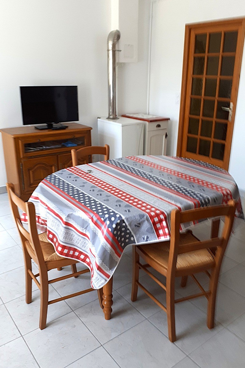 Pièce de vie avec une cuisine équipée (four, micro-ondes, plaques gaz, combiné congélation, etc), une table pour vos repas et une TV.