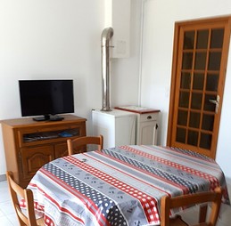 Pièce de vie avec une cuisine équipée (four, micro-ondes, plaques gaz, combiné congélation, etc), une table pour vos repas et une TV.