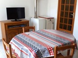 Living room with fully-equipped kitchen (oven, microwave, gas hob, freezer, etc.), dining table and TV.