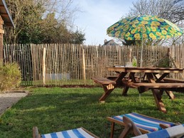 Jardin privatif avec salon de jardin, parasol, transats et jeux d'extérieur