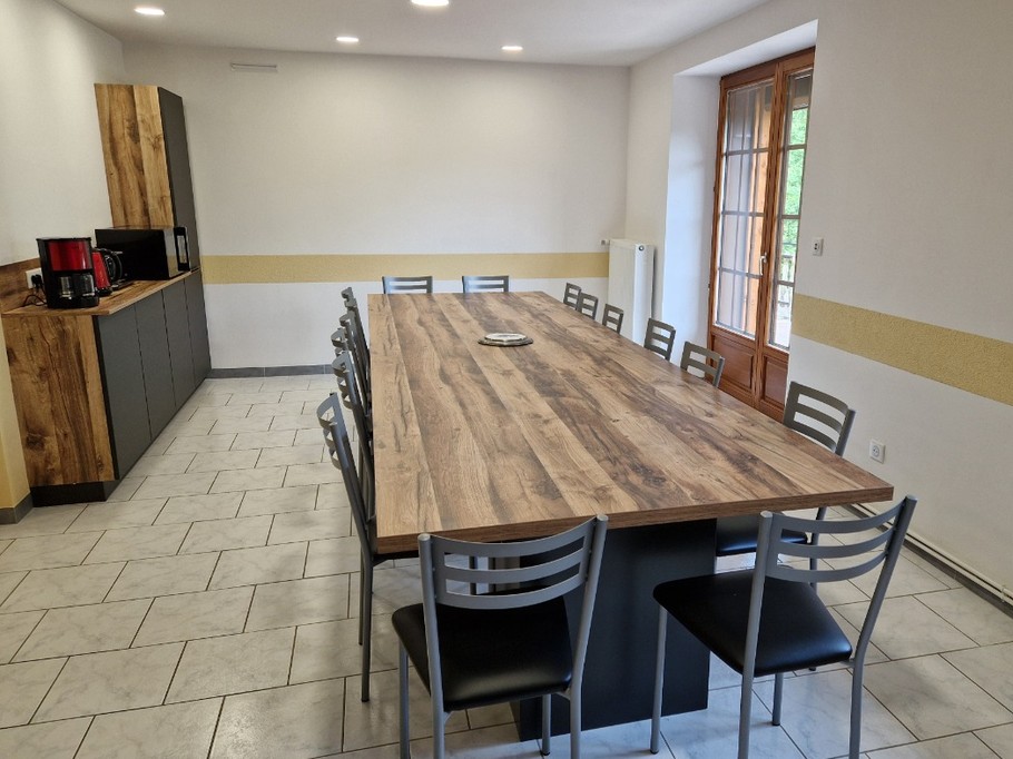 Table dans la salle à manger ouverte sur la cuisine en rez-de-chaussée - Gîte de la Haute Hardoye (14 pers) dans les Vosges