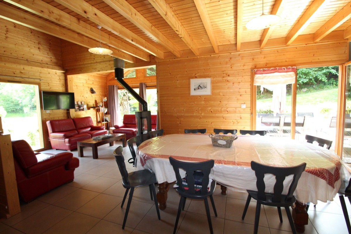 Salon/ séjour  - Large table pouvant accueillir 10 adultes à 2 chaises hautes pour enfants. Porte fenêtre sur terrasse extérieure.