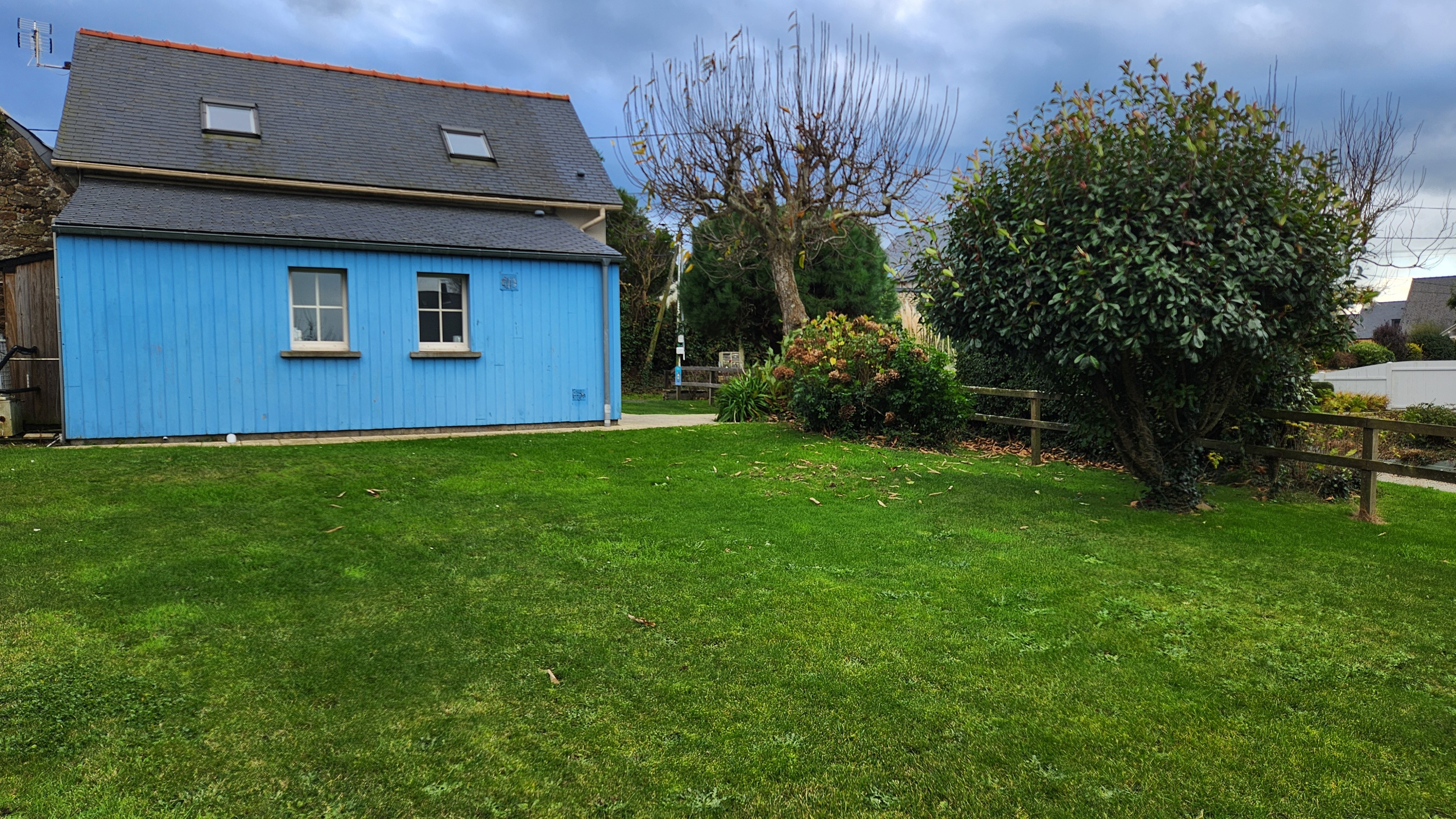 Façade arrière de la maison de vacances avec terrasse et jardin