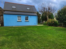 Façade arrière de la maison de vacances avec terrasse et jardin