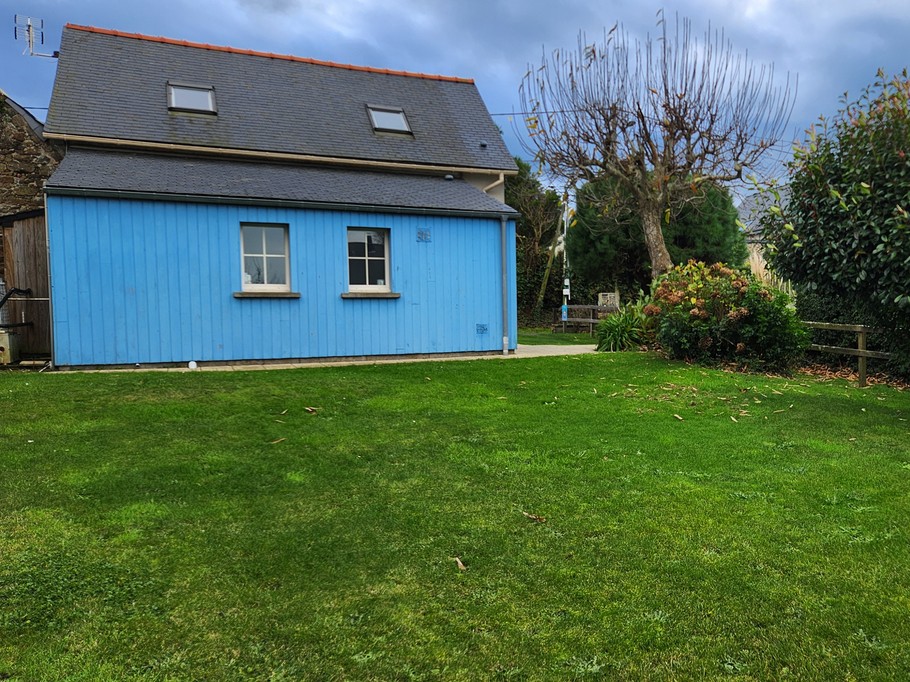 Façade arrière de la maison de vacances avec terrasse et jardin