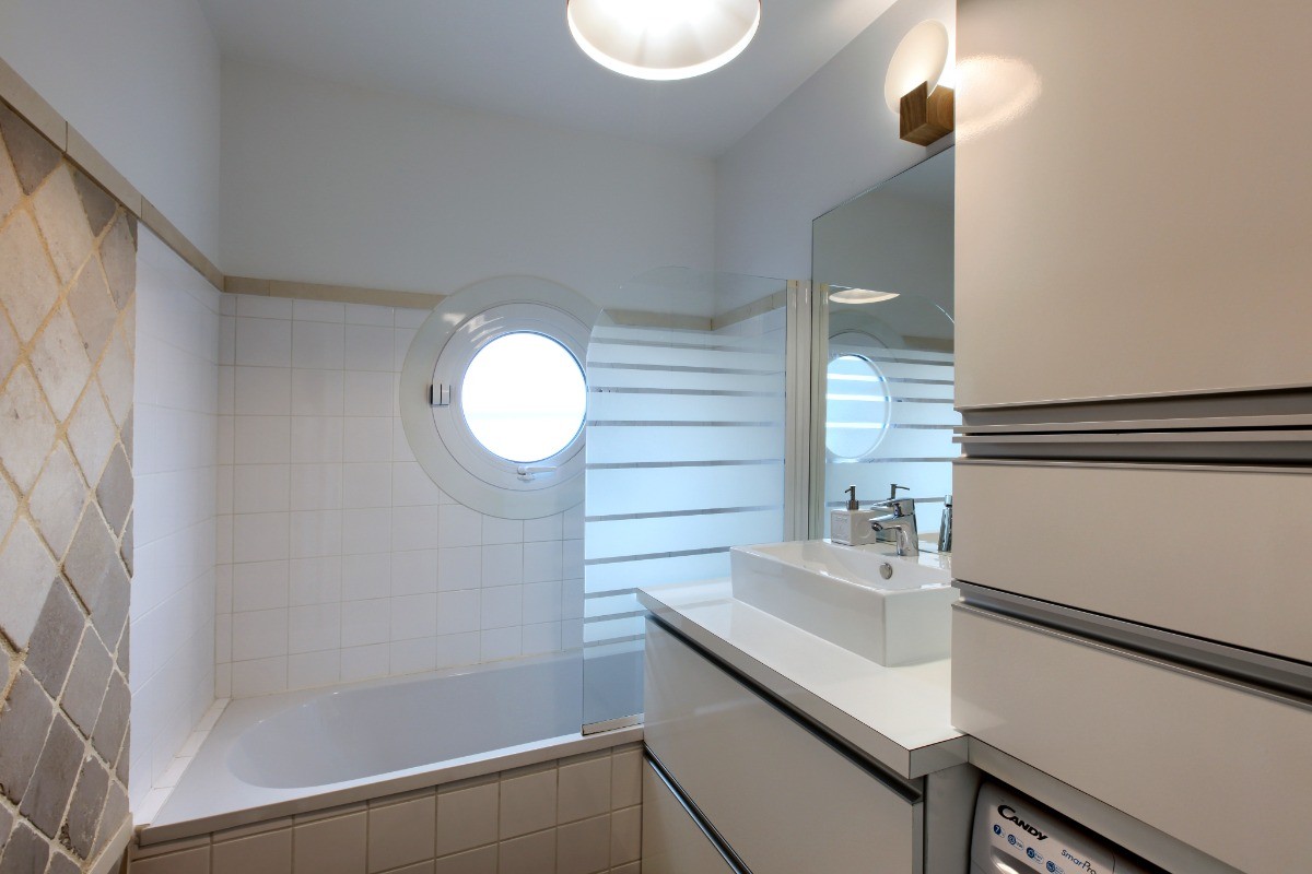 Salle de bain, baignoire, machine à laver, et nombreux rangements