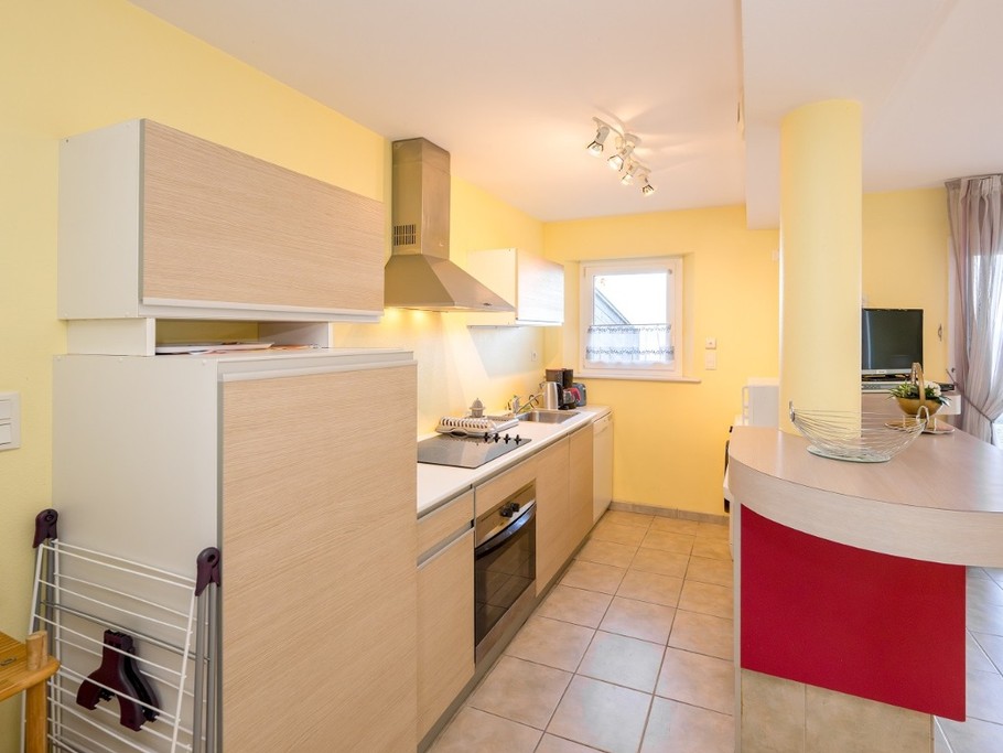 coin cuisine, avec lave linge et lave vaisselle, micro ondes, four et frigo avec partie congélation.