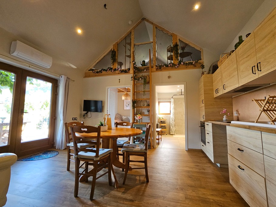Open-plan living area with a fitted kitchen, lounge and dining table.