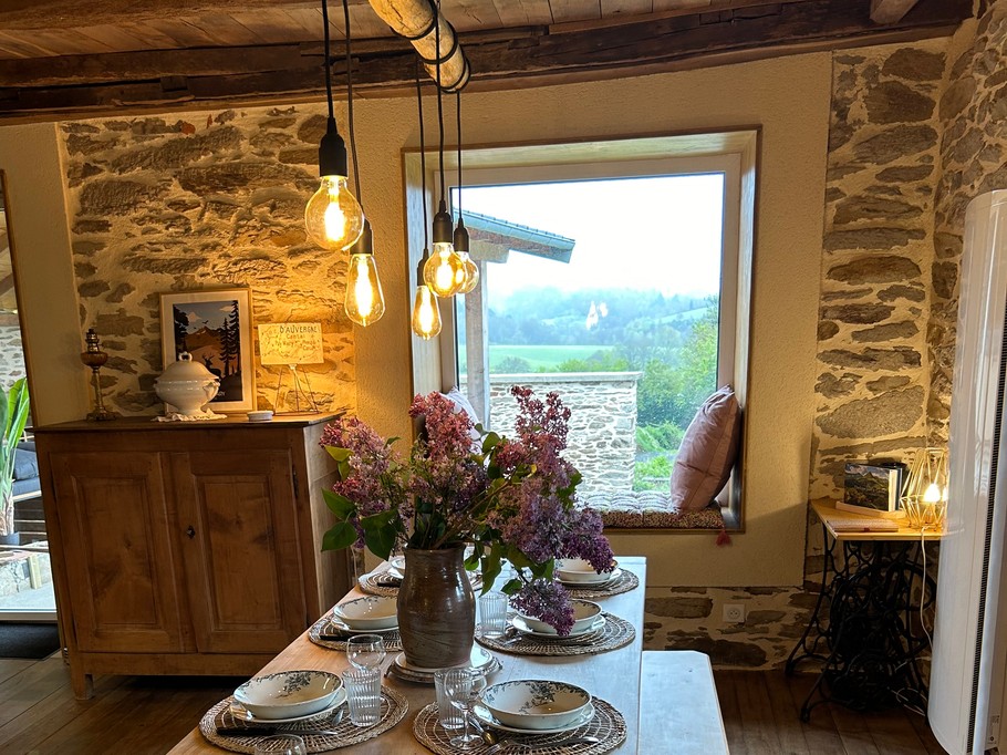 Table de ferme avec bancs qui offre une vue sur l'extérieur devant le coin lecture très apprécié