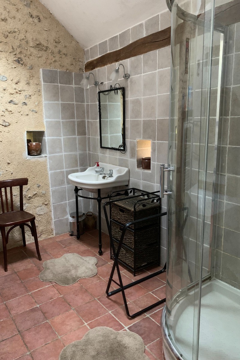 Salle d'eau spacieuse au rez-de-chaussée avec douche grande dimension. WC séparé à proximité.