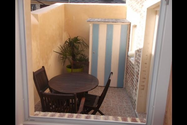 petite cour ensoleillée avec cabane renfermant 2 vélos à disposition