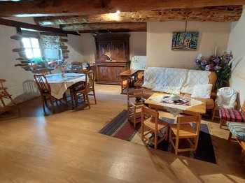 Petit salon chaleureux avec canapé, idéal pour un moment convivial ou un temps de lecture dans la maison d'hôtes