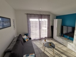 Espace salon avec TV donnant sur terrasse