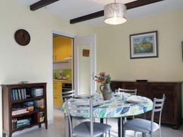 Bright living room with round table seating 4. Opening onto the garden