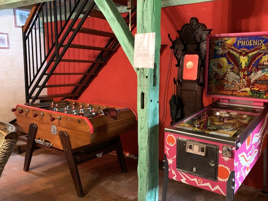 Second séjour avec jeux vintage (babyfoot, flipper, jeux d'arcade). Canapé-lit convertible pour 2 personnes (140x190 cm). Dessert la cuisine à gauche, le salon à droite, les chambres à l'étage.