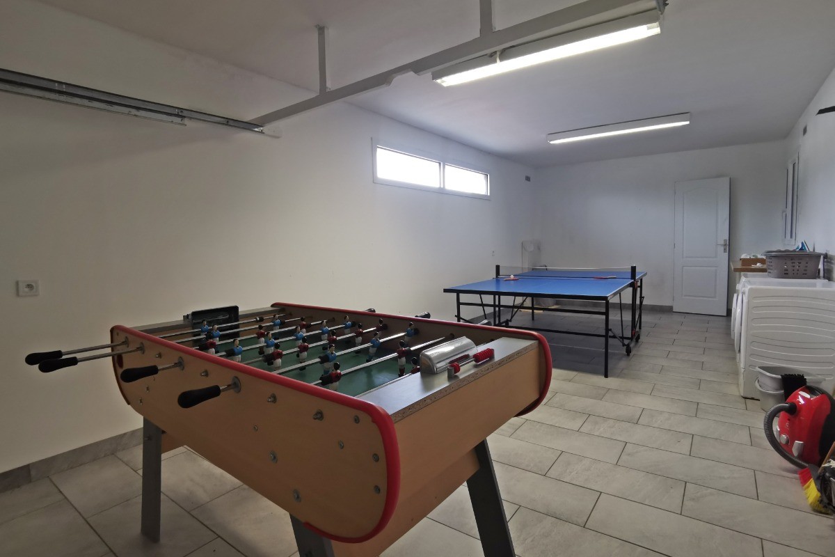 Garage avec baby-foot, table de ping-pong et buanderie