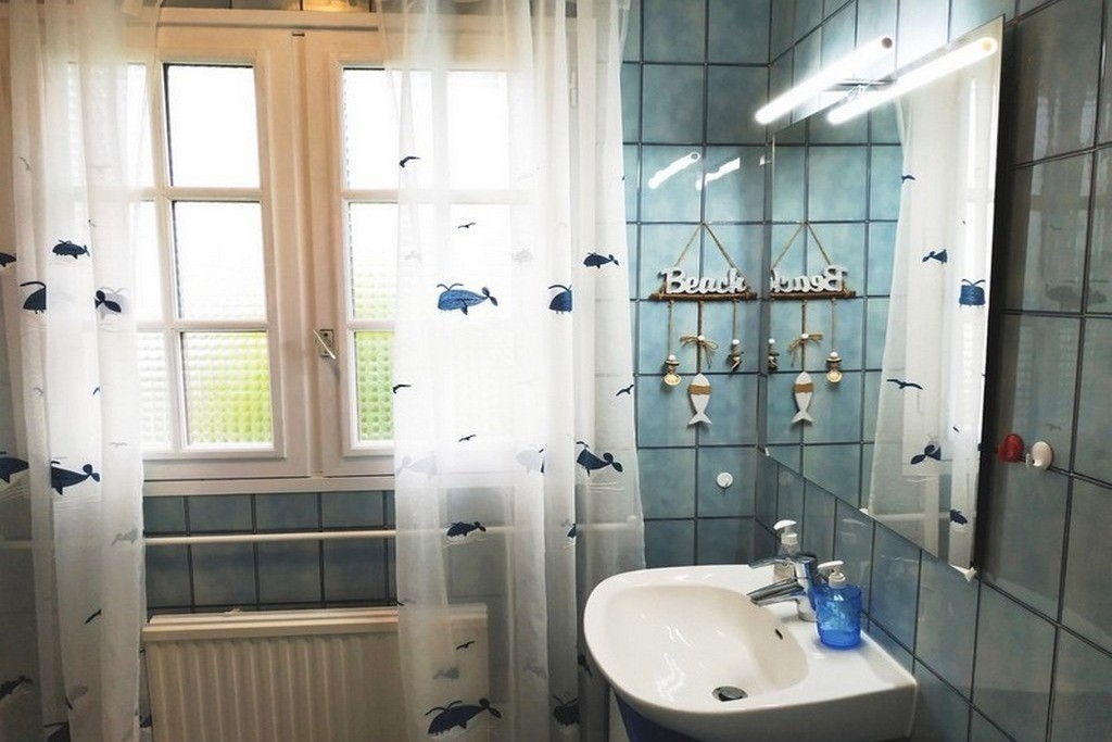 Une grande salle de bains, bien agencée, avec baignoire et de nombreux rangements