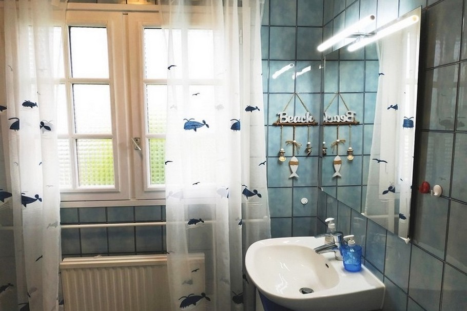 Une grande salle de bains, bien agencée, avec baignoire et de nombreux rangements
