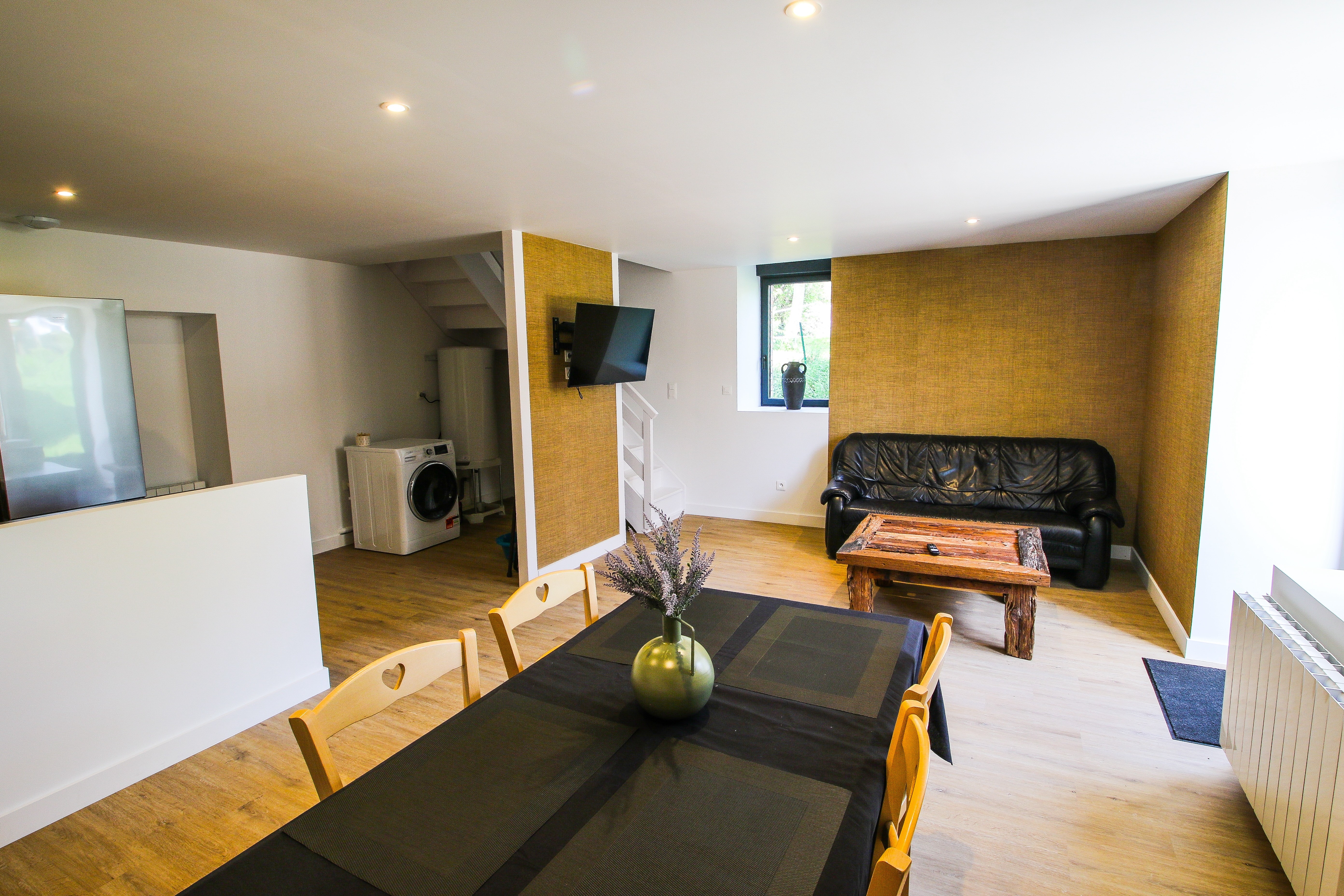 Pièce de vie au RDC avec espace salon et TV, espace séjour et espace cuisine toute équipée (congélateur, plaques induction, machine à café + expresso, etc.).
Machine à laver