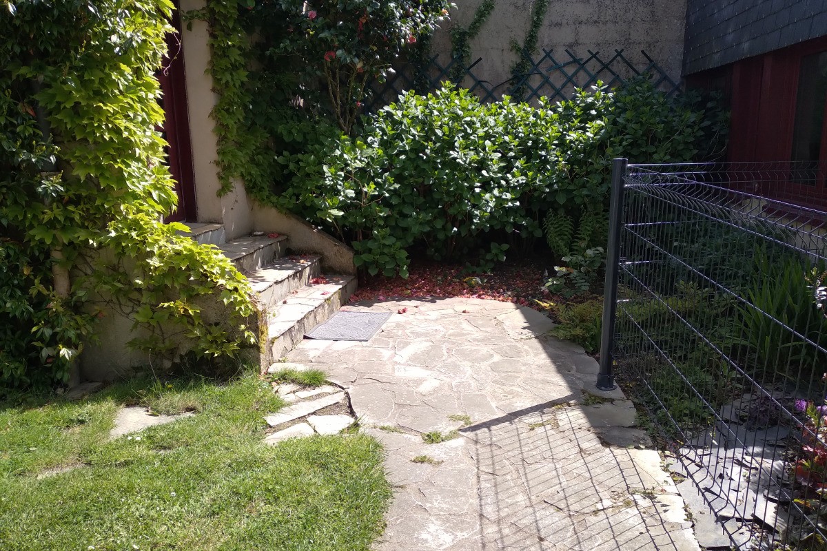 Façade de la maison fleurie au gré des saisons. Quelques marches pour accéder à la propriété puis à la location.