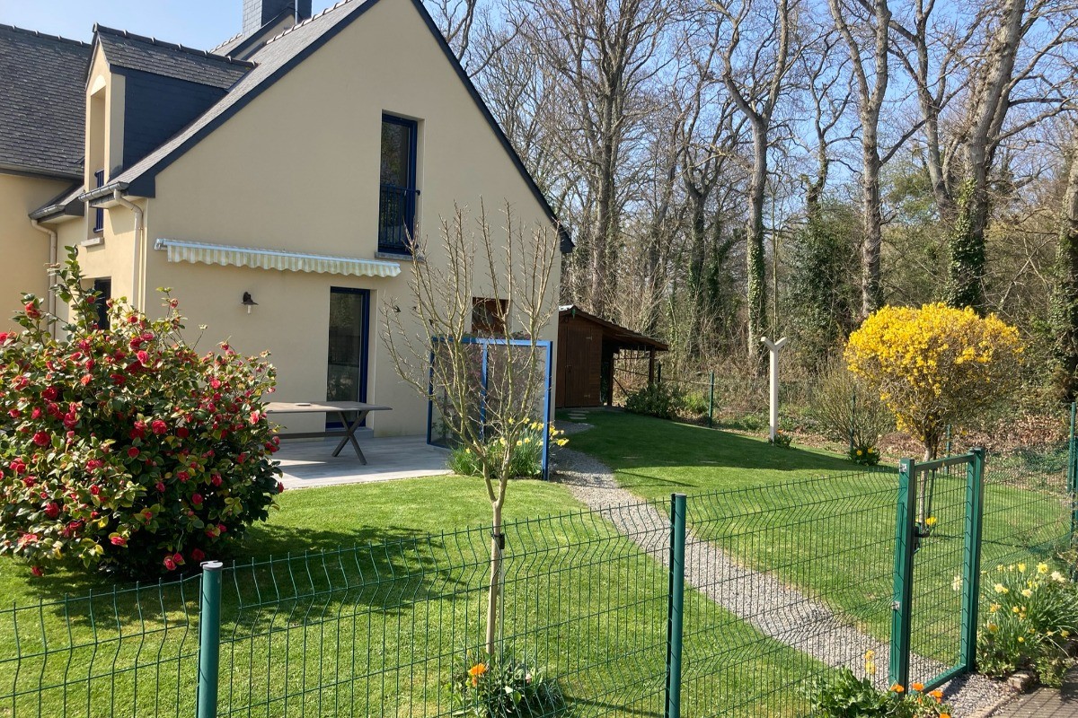 La maison bordée de grands arbres respire la tranquillité.