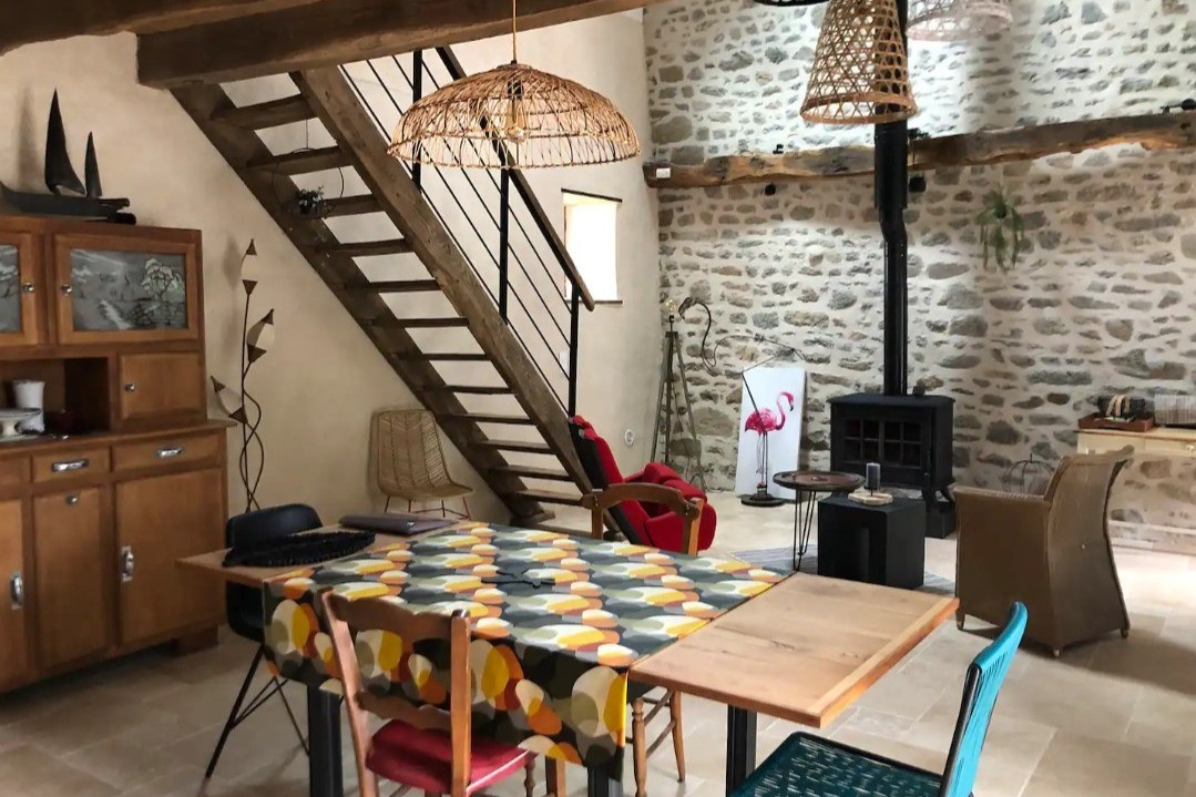 Grande pièce de vie rénovée en respectant l'âme du lieu, et meublée avec du mobilier finement chiné.