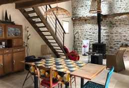 Grande pièce de vie rénovée en respectant l'âme du lieu, et meublée avec du mobilier finement chiné.