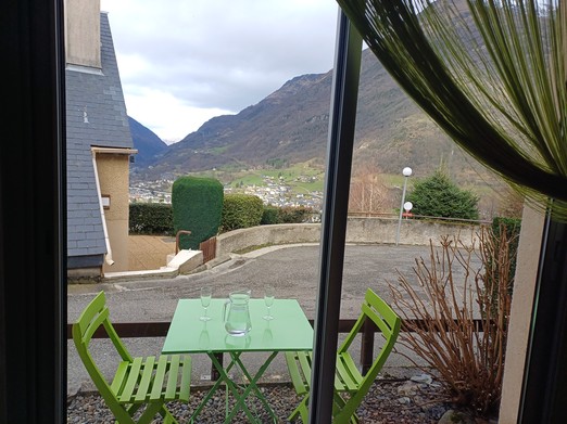 Table avec chaise devant la baie vitrée du séjour