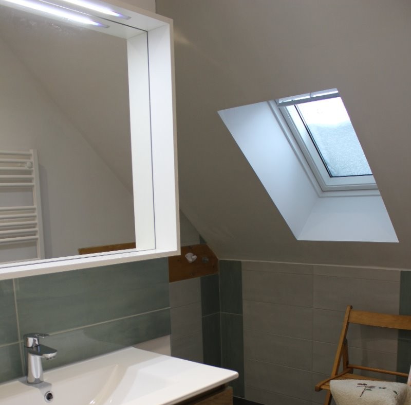 La salle de bain avec vasque, miroir et volumes de rangement