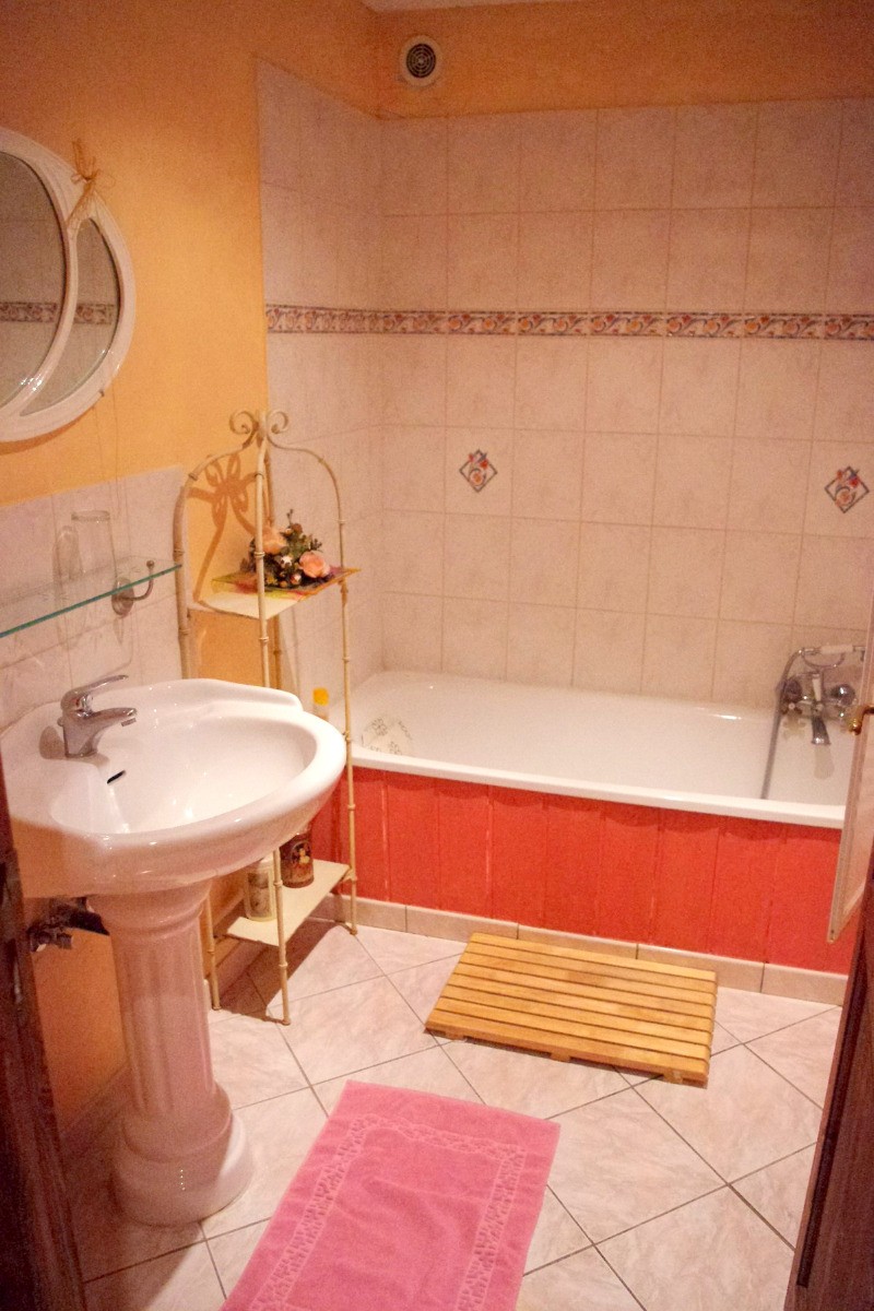 Une salle de bains avec une grande baignoire, et des toilettes séparées équipent la chambre.